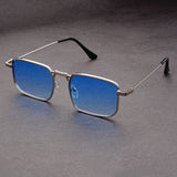 Blue-tinted sunglasses with thin metal frame on a gray background